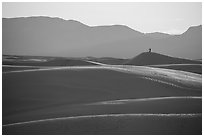 Photographer with tripod on tall dune at sunset. White Sands National Park ( black and white)