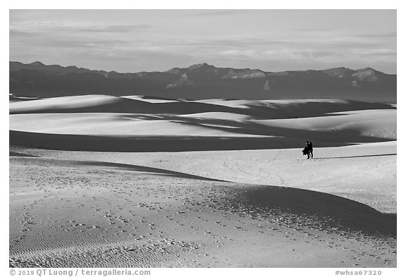 Couple hiking on dunes. White Sands National Park (black and white)