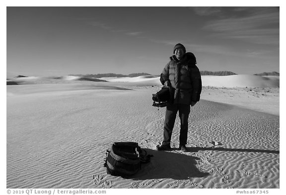 Photographer holding large format camera. White Sands National Park (black and white)
