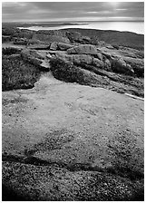 View over Atlantic from top of Mt Cadillac with granite slab covered with lichen. Acadia National Park, Maine, USA. (black and white)