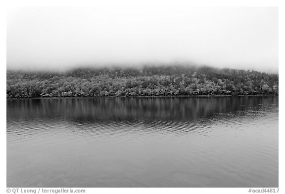 Hill reflected in Jordan Pond with top covered by fog. Acadia National Park, Maine, USA.