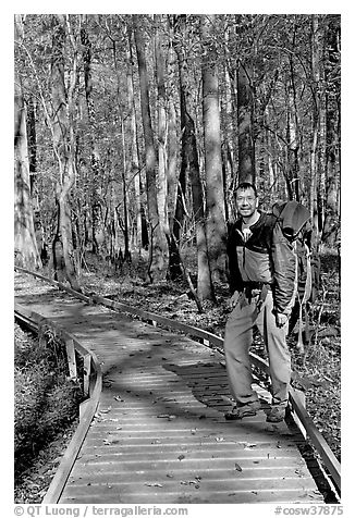 Hiker with backpack standing on boardwalk. Congaree National Park (black and white)