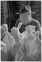 Miller sitting behind bags of cornmeal, North Carolina. Great Smoky Mountains National Park, USA. (black and white)