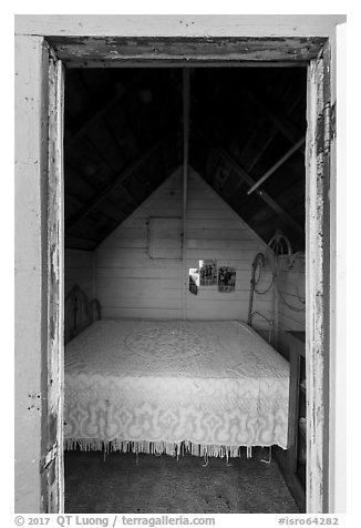 Bed framed by door of single-room Honeymoon cabin, Edisen Fishery. Isle Royale National Park (black and white)