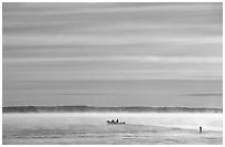 Boaters in fog, early morning, Kabetogama lake. Voyageurs National Park, Minnesota, USA. (black and white)