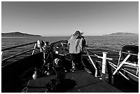 Woman standing on bow of boat sailing towards Annacapa and Santa Cruz Islands. Channel Islands National Park ( black and white)