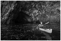 Kayaker paddling out of sea cave, Santa Cruz Island. Channel Islands National Park ( black and white)