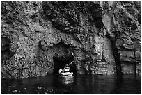 Kayaker entering narrow sea cave, Santa Cruz Island. Channel Islands National Park ( black and white)