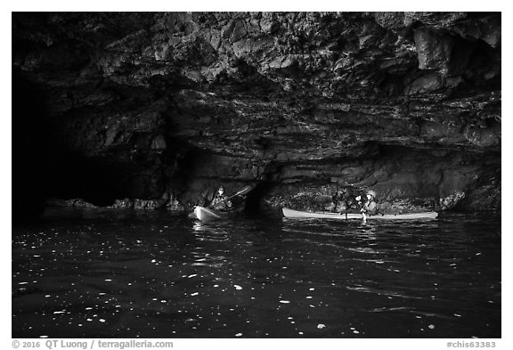 Two kayakers in sea cave with low ceiling, Santa Cruz Island. Channel Islands National Park (black and white)