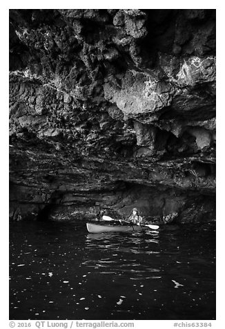 Kayaker in sea cave with low ceiling, Santa Cruz Island. Channel Islands National Park (black and white)