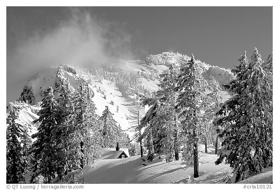 Trees, cabin, and Mt Garfield in winter. Crater Lake National Park, Oregon, USA.