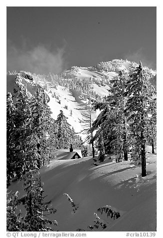 Cabin in winter with trees and mountain. Crater Lake National Park, Oregon, USA.