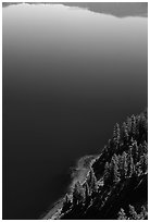 Trees and blue lake waters. Crater Lake National Park, Oregon, USA. (black and white)