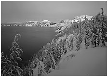 Snow-covered rim and trees, lake and mountains, dusk. Crater Lake National Park, Oregon, USA. (black and white)