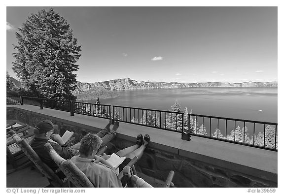 Reading on Crater Lake Lodge Terrace overlooking  Lake. Crater Lake National Park, Oregon, USA.