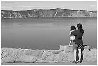 Woman and baby looking at Crater Lake. Crater Lake National Park, Oregon, USA. (black and white)
