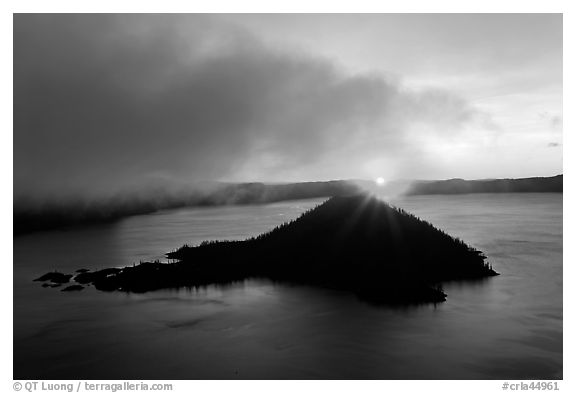 Sun rising behind Wizard Island. Crater Lake National Park, Oregon, USA.