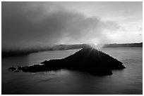 Sun rising behind Wizard Island. Crater Lake National Park, Oregon, USA. (black and white)