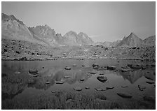 Mt Agasiz, Mt Thunderbolt, and Isoceles Peak reflected in a lake in Dusy Basin, sunset. Kings Canyon National Park, California, USA. (black and white)