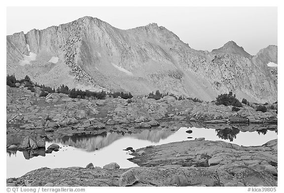 Mountains reflected in calm alpine lake at dawn, Dusy Basin. Kings Canyon National Park, California, USA.