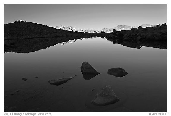 Rocks and calm lake with reflections, early morning, Dusy Basin. Kings Canyon National Park, California, USA.
