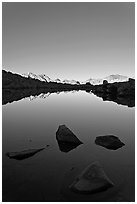 Rocks and calm lake with mountain reflections, early morning, Dusy Basin. Kings Canyon National Park, California, USA. (black and white)