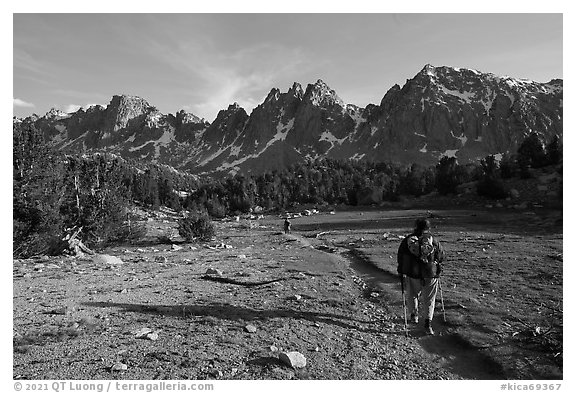 Backpackers walking on trail in meadow towards mountains. Kings Canyon National Park (black and white)