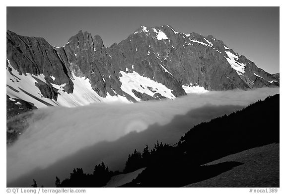 Sun projected on fog below peaks, early morning, Cascade Pass area, North Cascades National Park.  (black and white)
