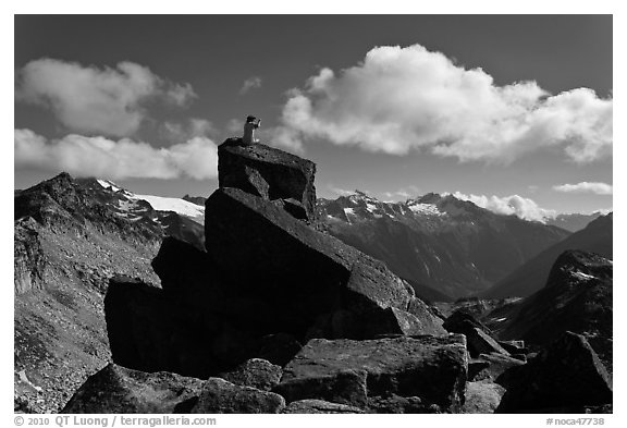Man sitting on rock photographs mountain panorama, North Cascades National Park.  (black and white)