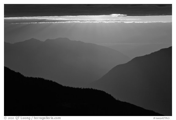 Layered ridges with sun behind clouds, North Cascades National Park.  (black and white)