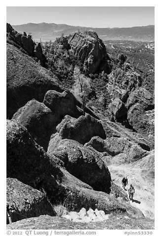 Hikers approaching cliff with steps carved in stone. Pinnacles National Park (black and white)