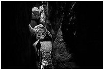 Hiker with lamp in Bear Gulch Cave. Pinnacles National Park ( black and white)
