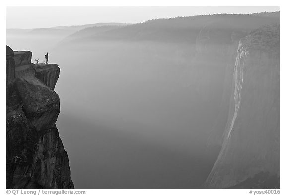 Hiker standing on top of sheer cliff at Taft point. Yosemite National Park, California, USA.