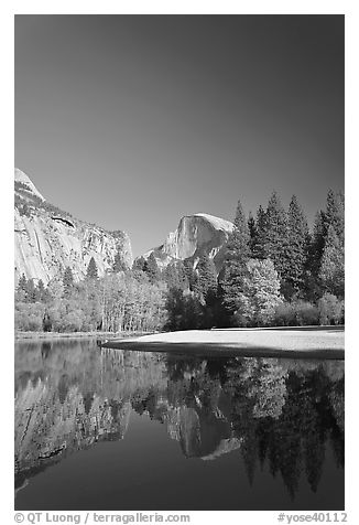 Trees in fall foliage and Half-Dome reflected in Merced River. Yosemite National Park, California, USA.