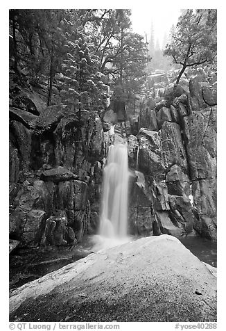 Snow-covered boulder and base of Chilnualna Falls. Yosemite National Park, California, USA.