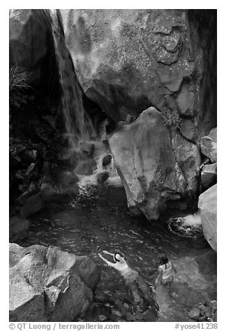 Swimmers in a pool at the base of Wapama falls, Hetch Hetchy. Yosemite National Park, California, USA.