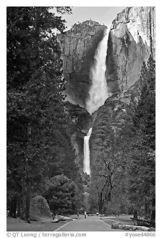 Tourists on path dwarfed by Upper and Lower Yosemite Falls. Yosemite National Park, California, USA.