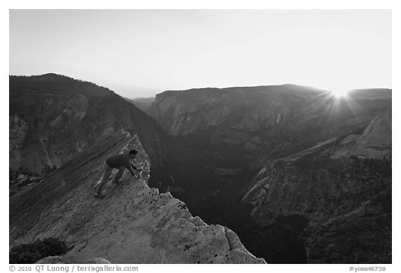 Hiker looking over the edge of the Diving Board, sunset. Yosemite National Park, California, USA.