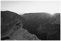Hiker looking over the edge of the Diving Board, sunset. Yosemite National Park, California, USA. (black and white)