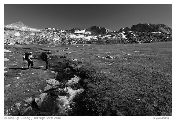 Backpackers crossing stream, Evelyn Lake. Yosemite National Park (black and white)