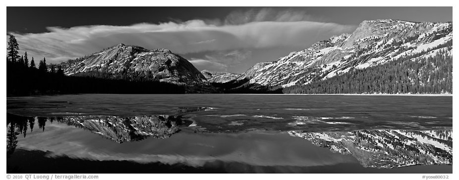 Mountains reflected in partly iced Tenaya Lake. Yosemite National Park, California, USA.