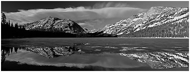 Mountains reflected in partly iced Tenaya Lake. Yosemite National Park, California, USA. (black and white)