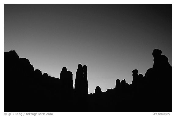 Sandstone pillars in Klondike Bluffs seen as silhouettes at dusk. Arches National Park, Utah, USA.