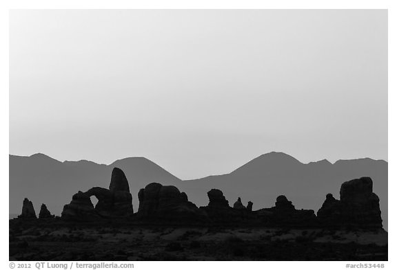 Turret Arch, spires, and mountains at dawn. Arches National Park, Utah, USA.