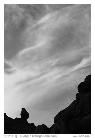 Sunset clouds and small balanced rock. Arches National Park, Utah, USA.