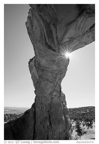 Sunburst at the crack of Broken Arch. Arches National Park, Utah, USA.
