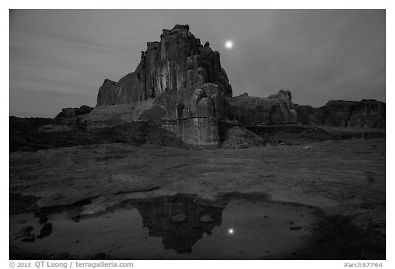 Courthouse tower and moon reflected in pothole. Arches National Park (black and white)