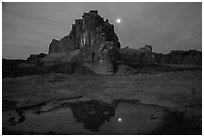 Courthouse tower and moon reflected in pothole. Arches National Park, Utah, USA. (black and white)