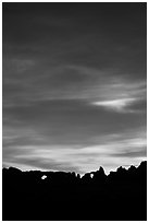 Windows and Turret Arch silhouetted against colorful clouds. Arches National Park, Utah, USA. (black and white)