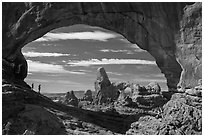 Family in the North Window span. Arches National Park, Utah, USA. (black and white)